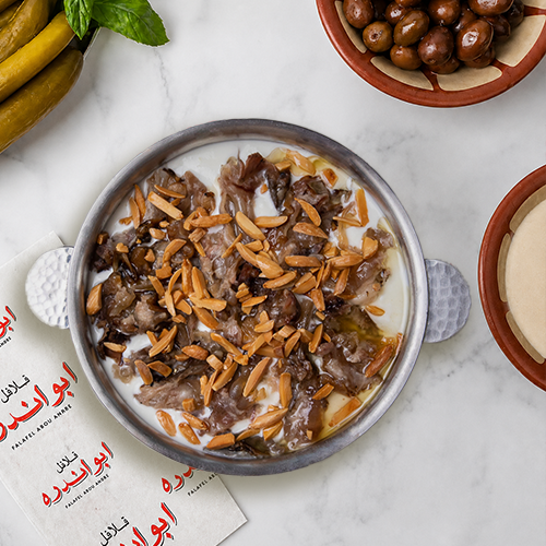 "Traditional Lebanese Fattet Maqadem at Falafel Abou Andre, tender sheep trotters layered with yogurt sauce and topped with toasted almonds."