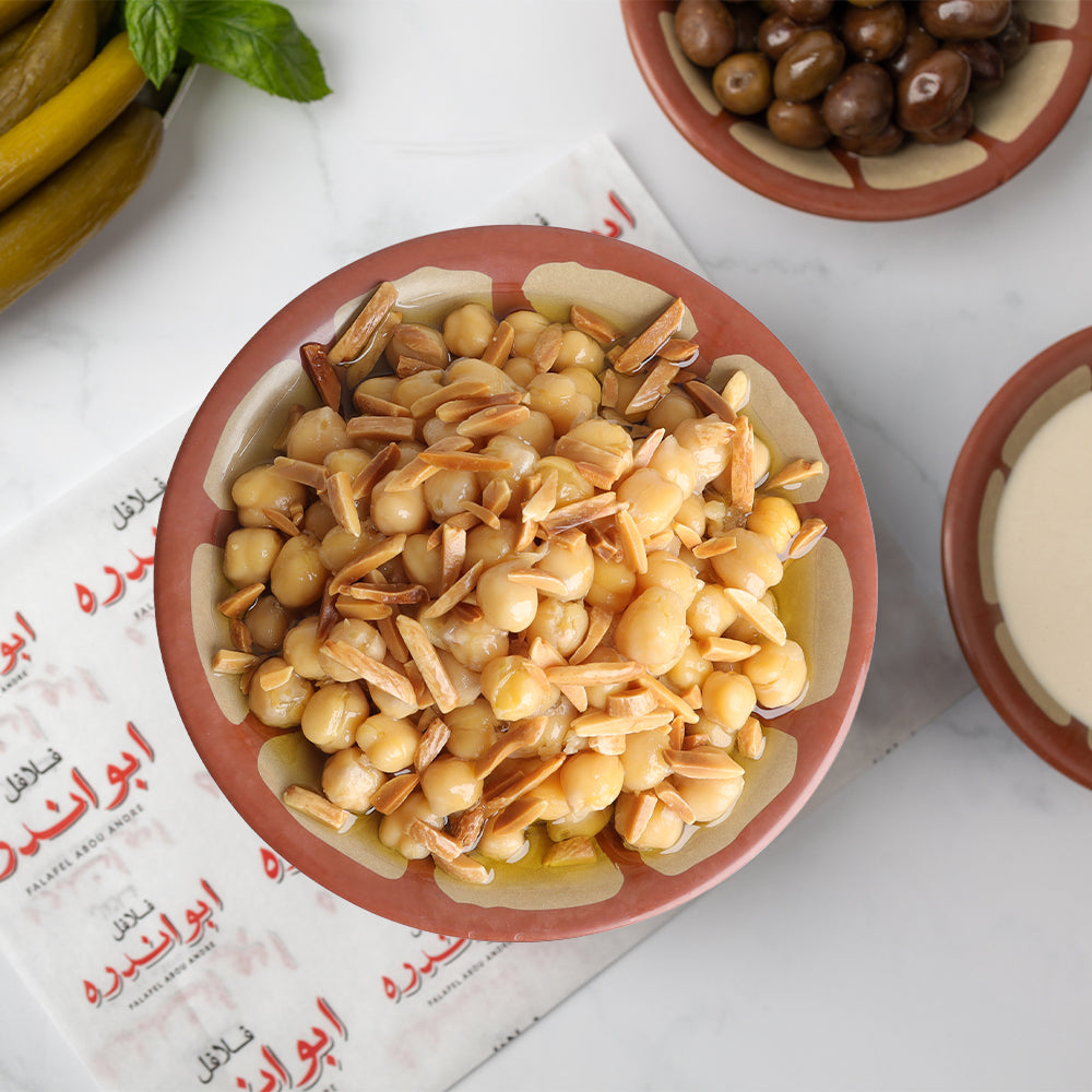 "Traditional Lebanese Balila plate with toasted nuts at Falafel Abou Andre, made with tender chickpeas, olive oil, cumin, and roasted almonds."