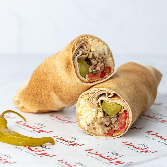 Lebanese Egg with Qwarma sandwich at Falafel Abou Andre made with fried eggs, spiced qawarma, comes with tomatoes, radish, onions, mint, pickled cucumber, and served in traditional Lebanese bread.