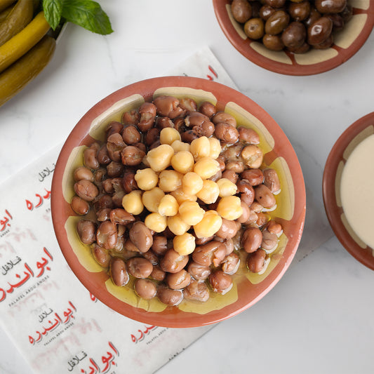 Lebanese Foul plate at Falafel Abou Andre featuring seasoned fava beans served with tomatoes, radishes, onions, fresh mint, pickled cucumbers and turnips, Lebanese olives, and traditional Lebanese bread