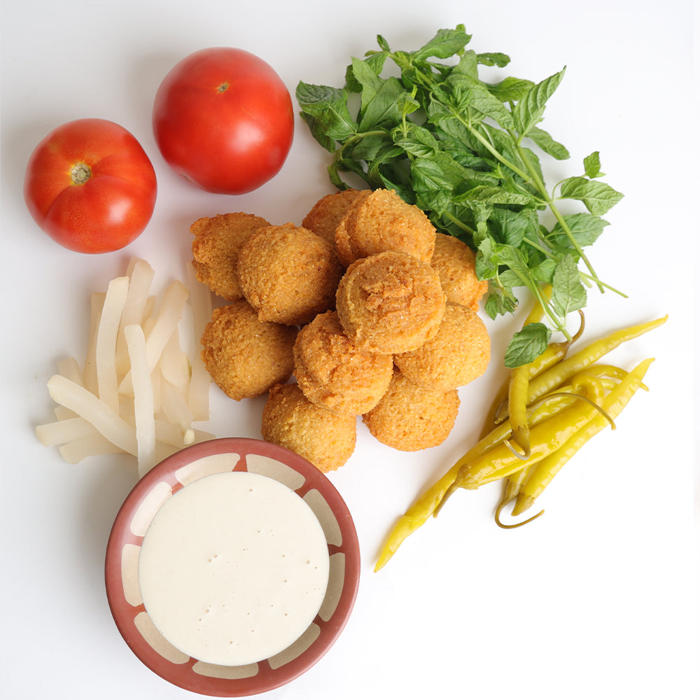 Lebanese Fresh falafel plate with pickles, tomatoes, and other vegetables - falafel abou andre